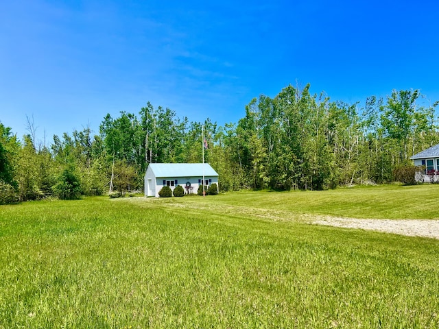 1745 Mullett Lake Woods Rd, Cheboygan, MI 49721 - view of green lawn with a garage