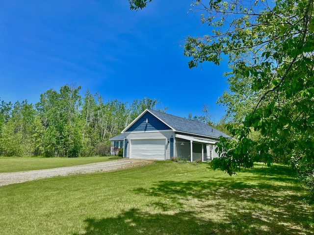1745 Mullett Lake Woods Rd, Cheboygan, MI 49721 - view of property exterior with driveway, an attached garage, and a lawn