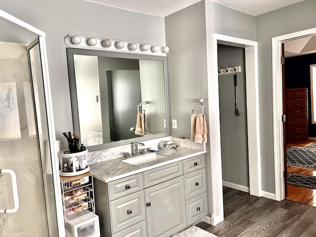 1745 Mullett Lake Woods Rd, Cheboygan, MI 49721 - bathroom featuring wood finished floors, vanity, and a textured ceiling