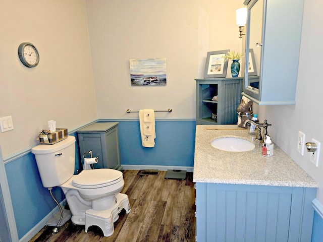 106 Hazel St, Saint Ignace, MI 49781 - bathroom with toilet, wood finished floors, vanity, and baseboards