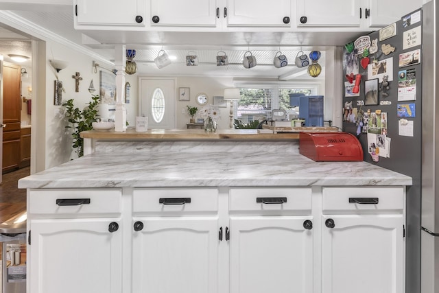 217 Cherry St, Houghton Lake, MI 48629 - kitchen with freestanding refrigerator, white cabinets, and light stone counters
