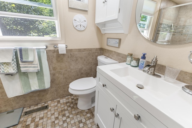 217 Cherry St, Houghton Lake, MI 48629 - full bath featuring tile walls, vanity, a stall shower, and wainscoting