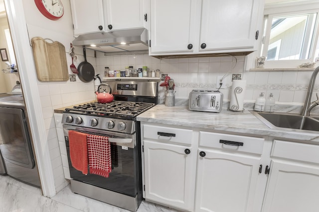 217 Cherry St, Houghton Lake, MI 48629 - kitchen featuring stainless steel range with gas cooktop, under cabinet range hood, washer / clothes dryer, and white cabinetry