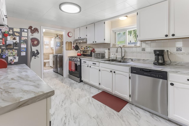 217 Cherry St, Houghton Lake, MI 48629 - kitchen with appliances with stainless steel finishes, independent washer and dryer, white cabinetry, under cabinet range hood, and backsplash