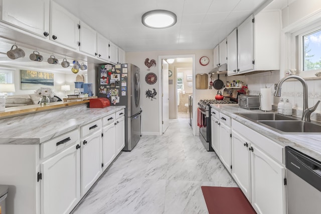 217 Cherry St, Houghton Lake, MI 48629 - kitchen with appliances with stainless steel finishes, under cabinet range hood, white cabinets, and light marble finish floors