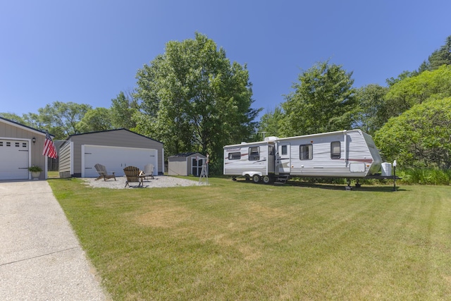 217 Cherry St, Houghton Lake, MI 48629 - view of front facade with a front lawn, a storage unit, and a garage