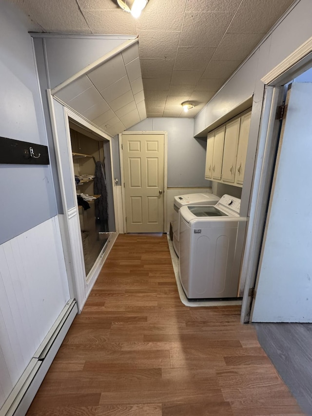 3134 Kneeland St, Lewiston, MI 49756 - laundry area with a baseboard heating unit, cabinet space, washer and dryer, and wood finished floors