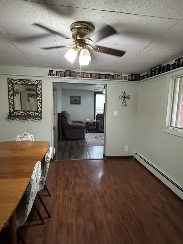 3134 Kneeland St, Lewiston, MI 49756 - dining room with dark wood finished floors, a baseboard heating unit, ceiling fan, and a drop ceiling