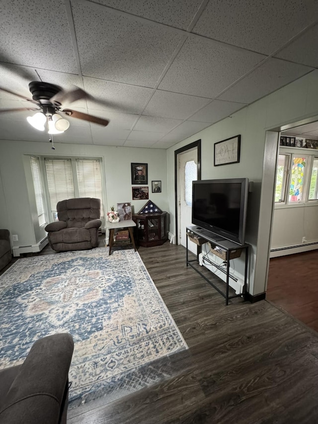 3134 Kneeland St, Lewiston, MI 49756 - living area with wood finished floors, a drop ceiling, a baseboard radiator, and a ceiling fan