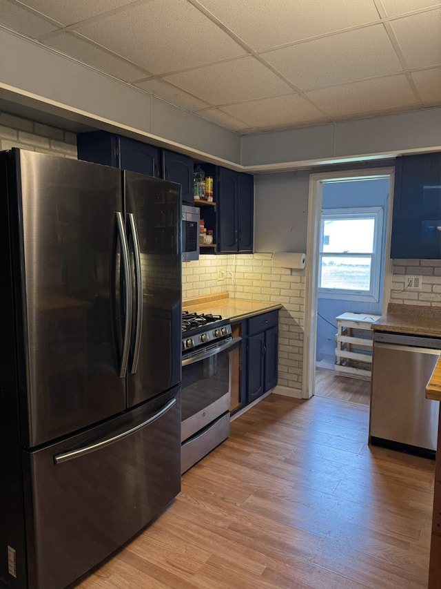 3134 Kneeland St, Lewiston, MI 49756 - kitchen with appliances with stainless steel finishes, blue cabinets, light wood-type flooring, a paneled ceiling, and open shelves