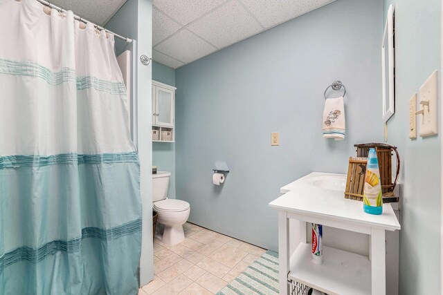 10702 Southwood Dr, Mancelona, MI 49659 - bathroom featuring a drop ceiling, toilet, a shower with shower curtain, and tile patterned floors