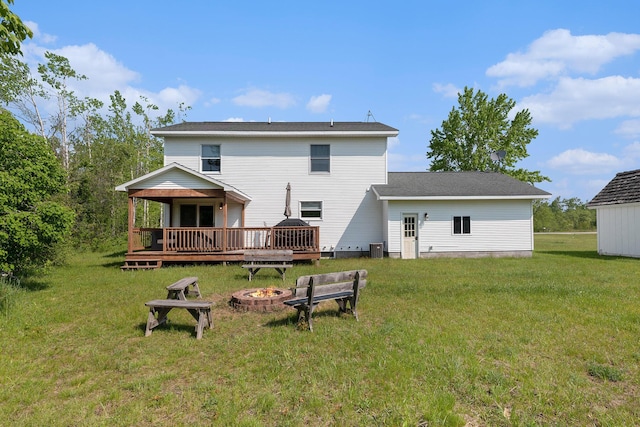 10702 Southwood Dr, Mancelona, MI 49659 - back of property featuring a fire pit, a deck, a yard, and cooling unit