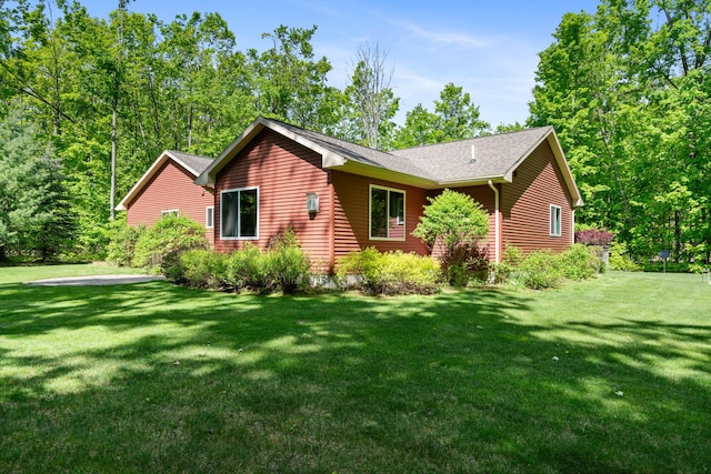 11193 Hassler Woods Trl, Alanson, MI 49706 - view of side of property with a yard and a shingled roof