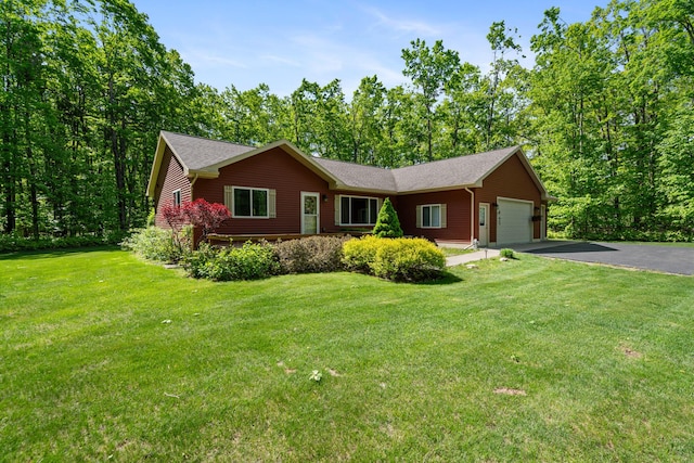 11193 Hassler Woods Trl, Alanson, MI 49706 - ranch-style home with an attached garage, asphalt driveway, and a front lawn