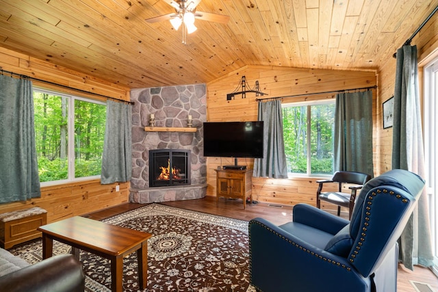 11193 Hassler Woods Trl, Alanson, MI 49706 - living room featuring wooden walls, wooden ceiling, lofted ceiling, ceiling fan, and a fireplace