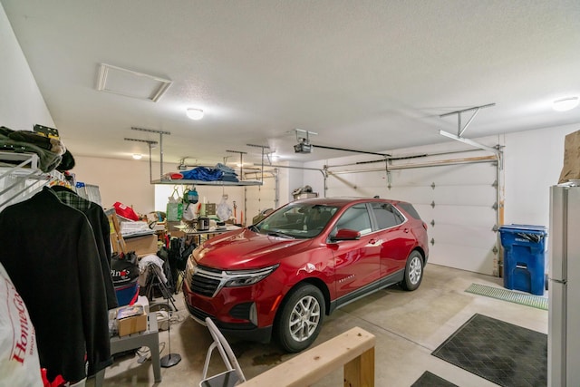 11193 Hassler Woods Trl, Alanson, MI 49706 - garage featuring freestanding refrigerator and a garage door opener