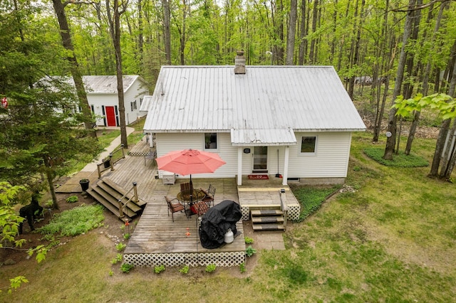 7106 Douglas Lake Rd, Johannesburg, MI 49751 - rear view of house featuring a chimney, metal roof, and a wooden deck