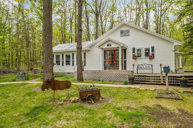 7106 Douglas Lake Rd, Johannesburg, MI 49751 - view of front of home with a front yard, a deck, and metal roof