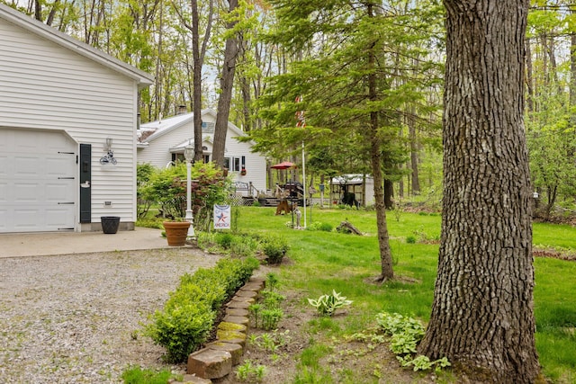 7106 Douglas Lake Rd, Johannesburg, MI 49751 - view of grassy yard featuring a garage