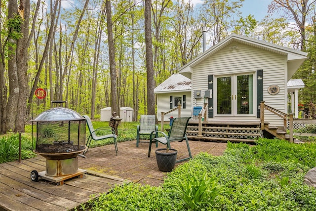 7106 Douglas Lake Rd, Johannesburg, MI 49751 - back of property with a fire pit, metal roof, french doors, and a patio area