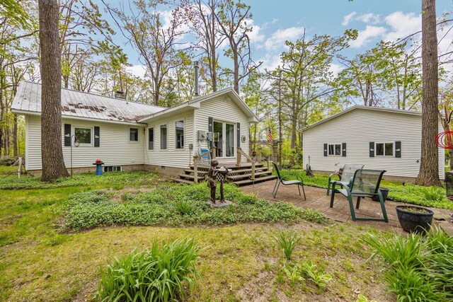 7106 Douglas Lake Rd, Johannesburg, MI 49751 - rear view of property featuring a deck, metal roof, a patio area, and a lawn