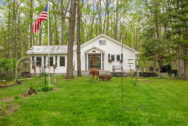 7106 Douglas Lake Rd, Johannesburg, MI 49751 - view of front of property featuring a deck, a front yard, and metal roof
