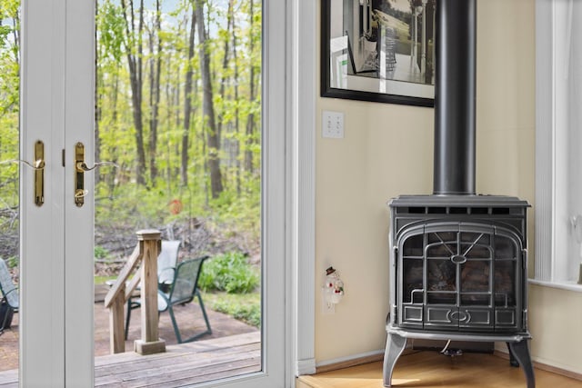 7106 Douglas Lake Rd, Johannesburg, MI 49751 - detailed view of a wood stove, baseboards, and wood finished floors