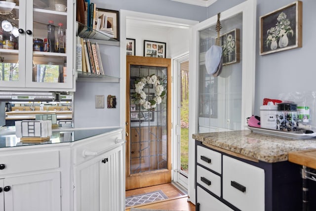 7106 Douglas Lake Rd, Johannesburg, MI 49751 - kitchen featuring white cabinets, ornamental molding, and glass insert cabinets