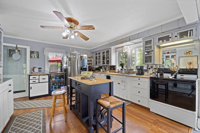 7106 Douglas Lake Rd, Johannesburg, MI 49751 - kitchen with white electric range, light wood finished floors, ornamental molding, a sink, and a ceiling fan