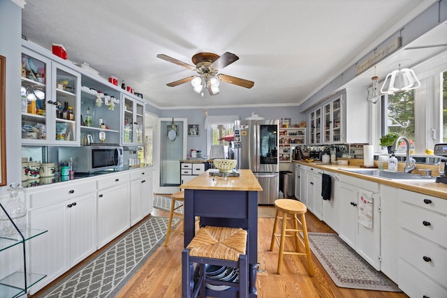 7106 Douglas Lake Rd, Johannesburg, MI 49751 - kitchen with a sink, stainless steel appliances, butcher block counters, healthy amount of natural light, and crown molding