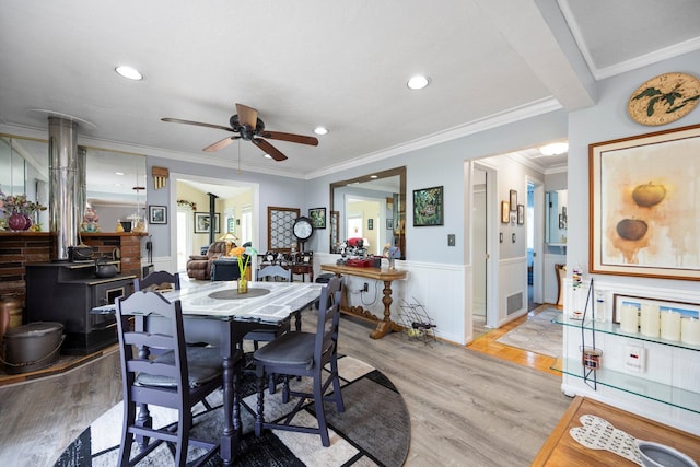 7106 Douglas Lake Rd, Johannesburg, MI 49751 - dining space featuring a ceiling fan, light wood-type flooring, a wainscoted wall, recessed lighting, and crown molding