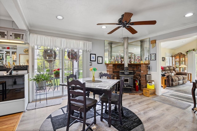 7106 Douglas Lake Rd, Johannesburg, MI 49751 - dining area featuring a wood stove, a ceiling fan, crown molding, light wood finished floors, and recessed lighting