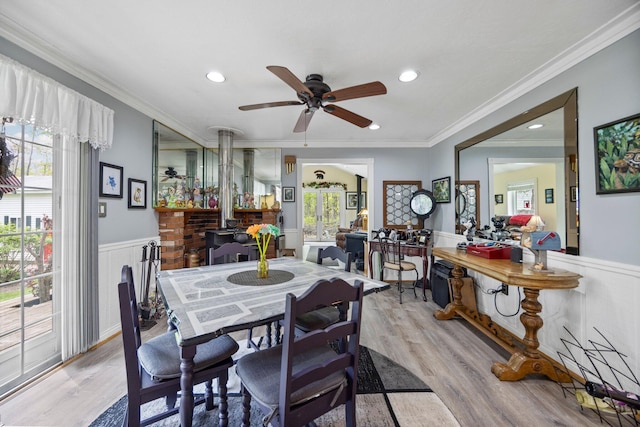 7106 Douglas Lake Rd, Johannesburg, MI 49751 - dining area featuring ceiling fan, wainscoting, healthy amount of natural light, light wood-type flooring, and crown molding