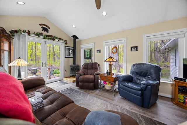 7106 Douglas Lake Rd, Johannesburg, MI 49751 - living area featuring a wood stove, french doors, wood finished floors, recessed lighting, and high vaulted ceiling
