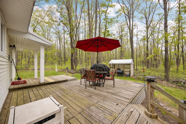 7106 Douglas Lake Rd, Johannesburg, MI 49751 - wooden deck with outdoor dining area and a wooded view