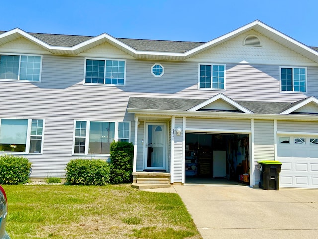 2476 W Branch Dr, West Branch, MI 48661 - view of front of property with concrete driveway, roof with shingles, an attached garage, and a front lawn