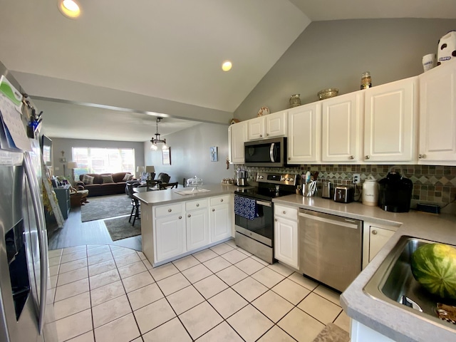 2476 W Branch Dr, West Branch, MI 48661 - kitchen with stainless steel appliances, vaulted ceiling, a peninsula, light countertops, and open floor plan