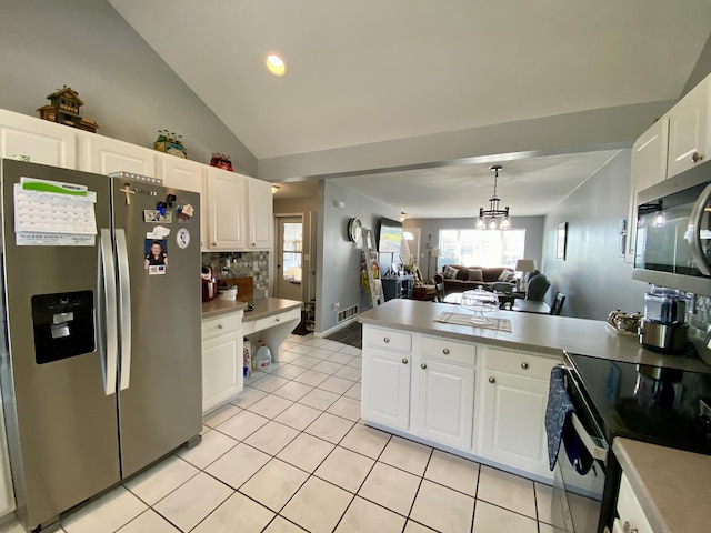 2476 W Branch Dr, West Branch, MI 48661 - kitchen featuring appliances with stainless steel finishes, a peninsula, white cabinets, light tile patterned floors, and open floor plan