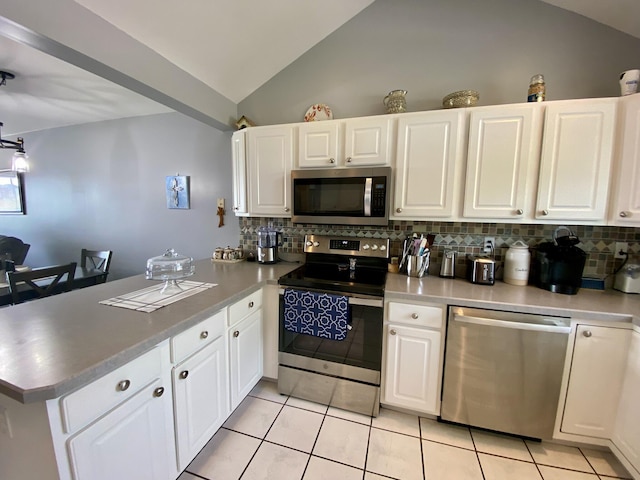 2476 W Branch Dr, West Branch, MI 48661 - kitchen featuring stainless steel appliances, a peninsula, lofted ceiling, backsplash, and light tile patterned floors