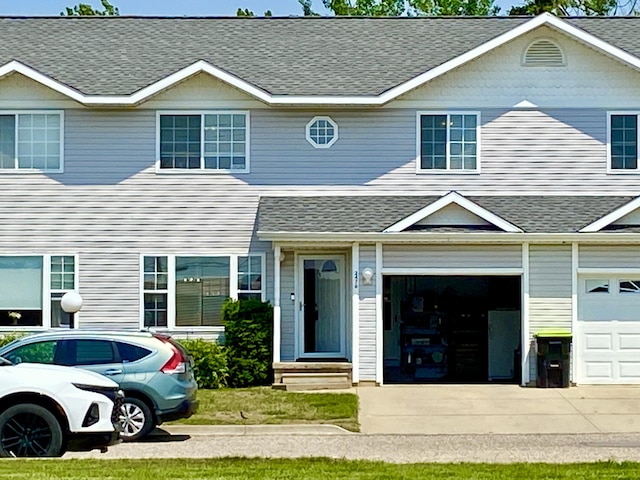 2476 W Branch Dr, West Branch, MI 48661 - view of front of property featuring roof with shingles, driveway, entry steps, and an attached garage