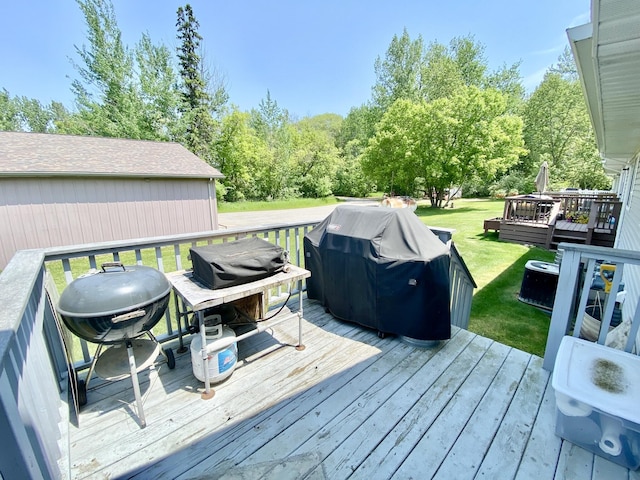2476 W Branch Dr, West Branch, MI 48661 - wooden deck with a lawn and area for grilling