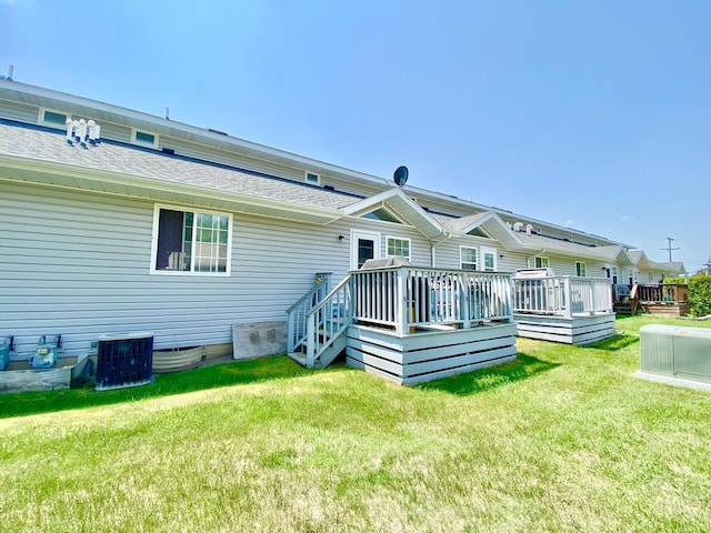 2476 W Branch Dr, West Branch, MI 48661 - back of property with central AC unit, a yard, a wooden deck, and roof with shingles