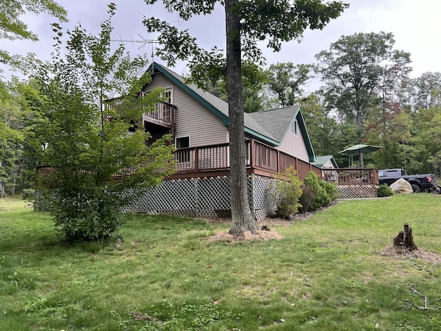 7781 N M-18, Roscommon, MI 48653 - view of home's exterior with a wooden deck and a lawn
