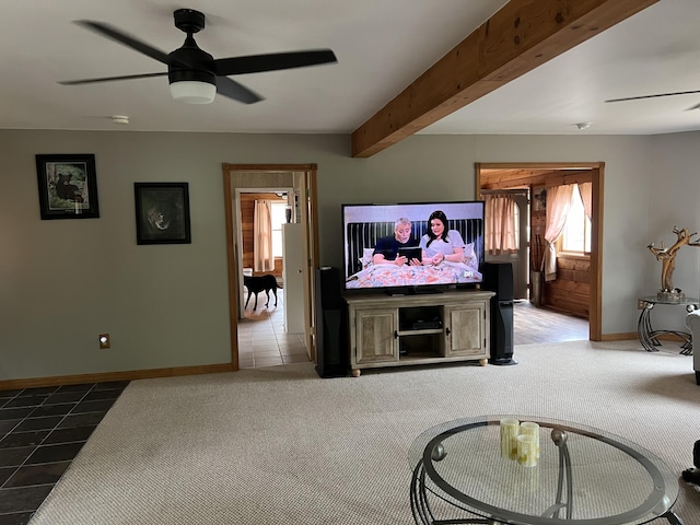 7781 N M-18, Roscommon, MI 48653 - carpeted living room featuring ceiling fan, baseboards, tile patterned flooring, and beamed ceiling