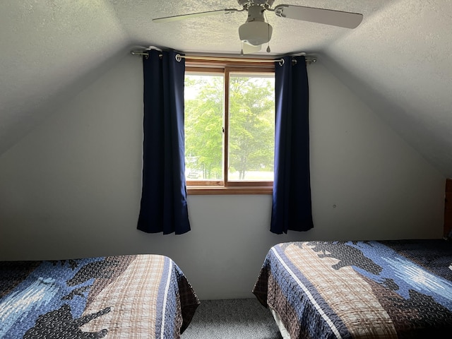 7781 N M-18, Roscommon, MI 48653 - bedroom with a textured ceiling, vaulted ceiling, carpet flooring, and a ceiling fan