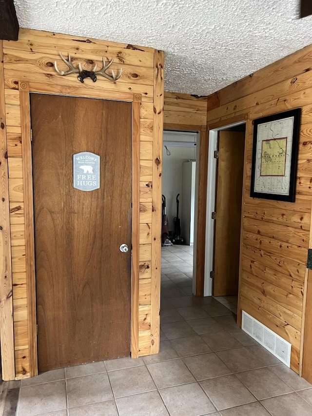 7781 N M-18, Roscommon, MI 48653 - tiled entryway featuring wooden walls and a textured ceiling