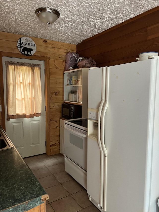 7781 N M-18, Roscommon, MI 48653 - kitchen with white appliances, light tile patterned floors, wood walls, a sink, and dark countertops