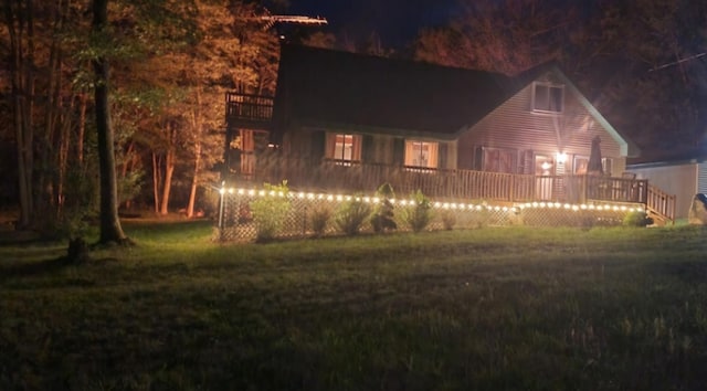 7781 N M-18, Roscommon, MI 48653 - back of house at twilight featuring a deck and a lawn