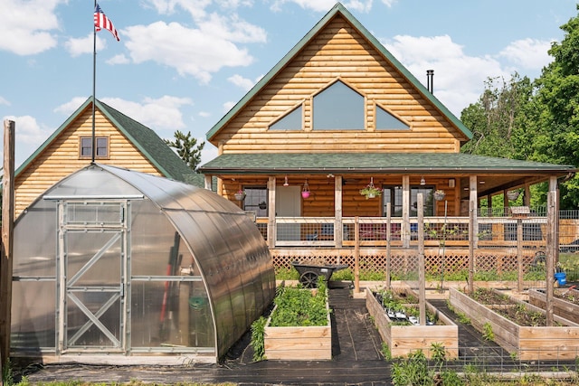 8406 S Shire Rd, Vanderbilt, MI 49795 - view of front facade with a vegetable garden, a greenhouse, an outdoor structure, and a shingled roof