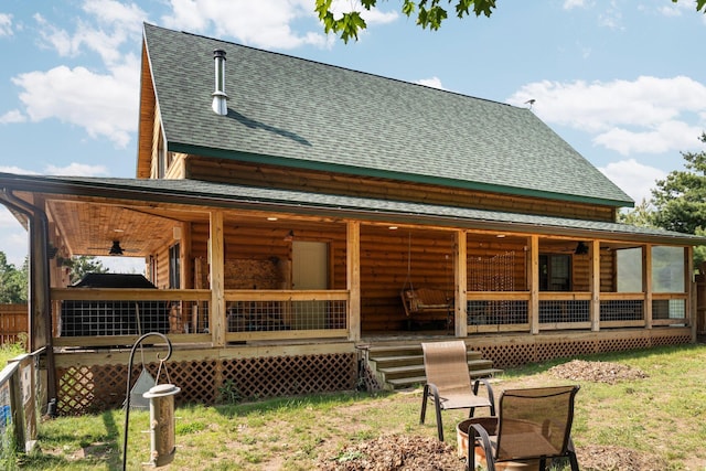 8406 S Shire Rd, Vanderbilt, MI 49795 - back of property with roof with shingles, covered porch, a lawn, and log veneer siding